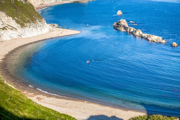 people enjoying a hot summer day on a beautiful hidden beach on the Jurassic Coast of Dorset, UK - Britiish summer holiday destination
