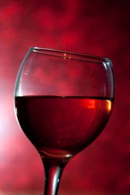 Kırmızı arka planda bir kadeh şarap. 