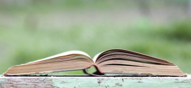 Yeşil bulanık arkaplanı olan kapatma kitabı 