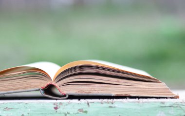 Yeşil bulanık arkaplanı olan kapatma kitabı 