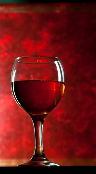 Een Glas Wijn Tegen Rode Achtergrond — Stockfoto