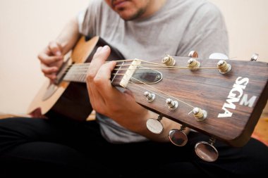 Evde gitar çalan adam.