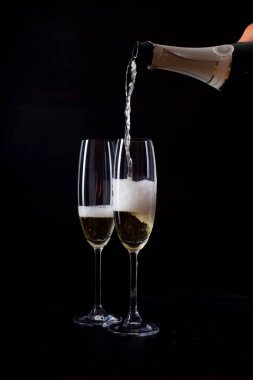 Şampanyayı siyah arka plana dökerek 