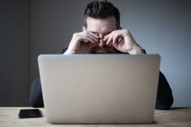 Yorgun işadamı gözlerine dokunuyor. Kötü görme, yorgunluk.