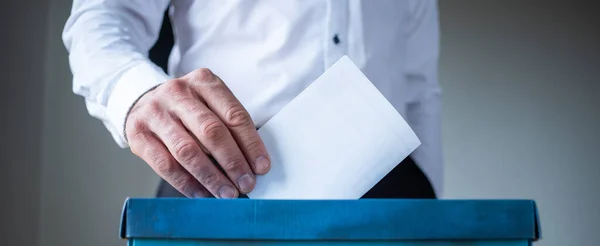 male hand putting vote in ballot