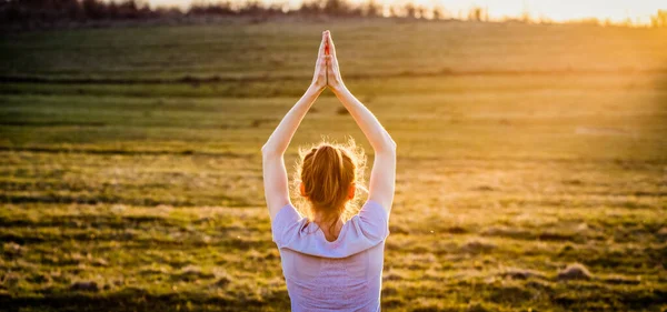 woman in a balancing pose at sunset yoga outdoors