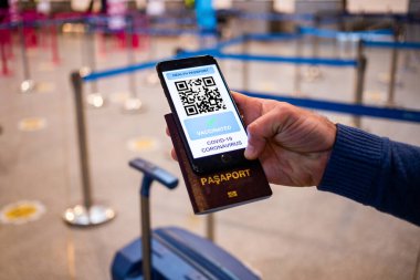 Coronavirus veya Covid-19 için sağlık aşısı pasaportu. Havaalanında Uluslararası Sertifikalı Seyahat İçin Bağışıklık Statüsünde Aşıyla Gezgin Cep Telefonu Kullanıyor