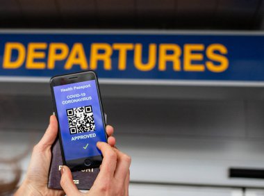 Coronavirus veya Covid-19 için sağlık aşısı pasaportu. Havaalanında Uluslararası Sertifikalı Seyahat İçin Bağışıklık Statüsünde Aşıyla Gezgin Cep Telefonu Kullanıyor