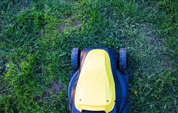 緑の芝生の黄色い芝生の芝刈り機の上からの眺め — ストック写真