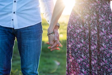 Gün batımında el ele tutuşan çift