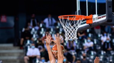 Basketbol bir spor sahasında çemberin içinden geçiyor 