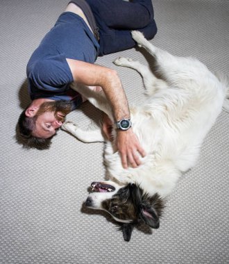 Adam yerde köpeğine sarılıyor.