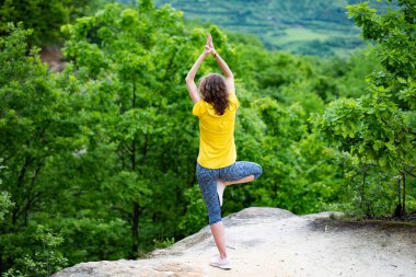 Kadınlar yazın dışarıda yoga yapıyor.