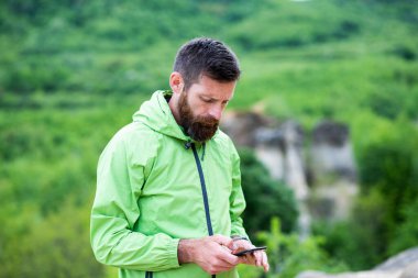 Adam yaz manzarasında akıllı telefondan haritayı kontrol ediyor