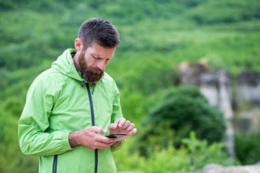 Adam yaz manzarasında akıllı telefondan haritayı kontrol ediyor