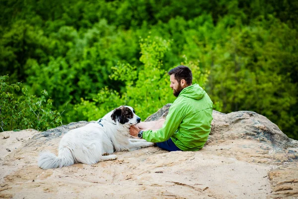 Köpeğiyle Bir Kayanın Üzerinde Oturan Adam Doğanın Tadını Çıkarıyor — Stok fotoğraf