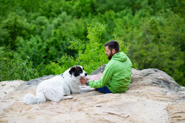 Köpeğiyle Bir Kayanın Üzerinde Oturan Adam Doğanın Tadını Çıkarıyor — Stok fotoğraf