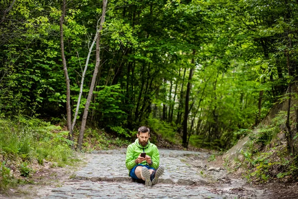 Uomo Seduto Nella Foresta Verde Guardare Telefono — Foto Stock