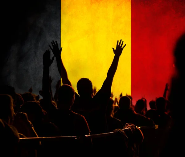 football fans supporting Belgium - crowd celebrating in stadium with raised hands against Belgium flag