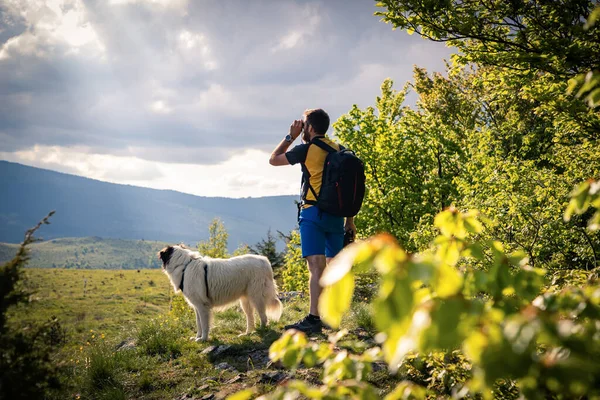 Przystojny Mężczyzna Biały Pies Trekking Przyrodzie Pomocą Lornetki Powolne Podróże — Zdjęcie stockowe