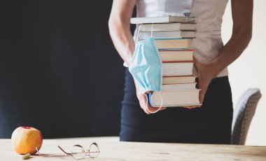 Kitap ve tıbbi maske yığını salgını sırasında okula geri döndüm.