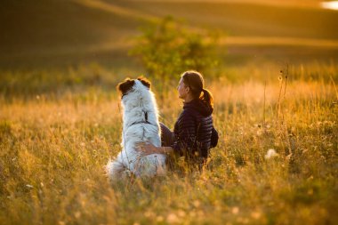Sonbahar manzarasında köpekli bir kadın oynuyor