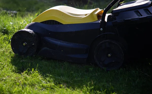 現代の庭の緑の芝生の上で芝刈り機 芝刈り機 — ストック写真
