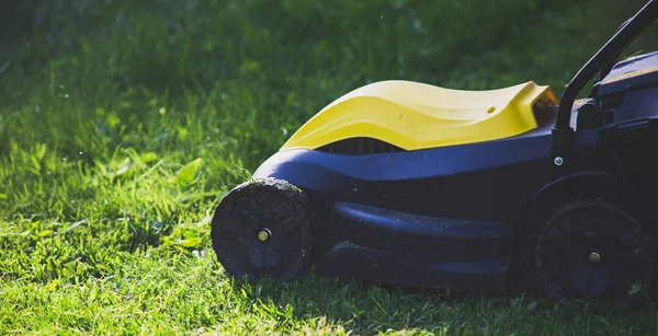 現代の庭の緑の芝生の上で芝刈り機 芝刈り機 — ストック写真