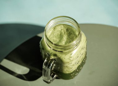 Yeşil ıspanak ve yeşil arka planda lahana suyu dolu mason kavanozu kupası.