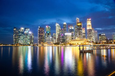 SINGAPORE, SINGAPORE - Mart 2019: Marina Körfezi kumları, Sanat Bilimi müzesi, gökdelenler ve turist tekneleri ile Singapur Marina Körfezi 'nin gece silueti