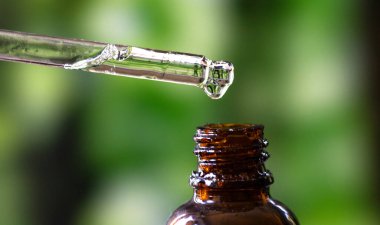 Yeşil arka planda kenevir yağı damlası