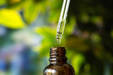 Yeşil arka planda kenevir yağı damlası