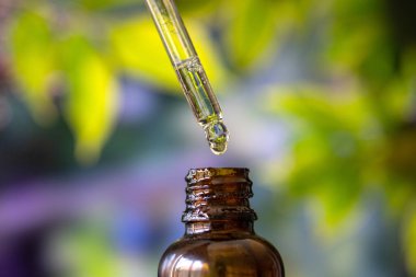 Yeşil arka planda kenevir yağı damlası