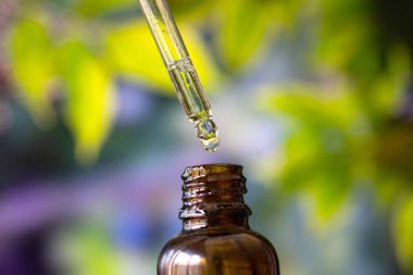 Yeşil arka planda kenevir yağı damlası