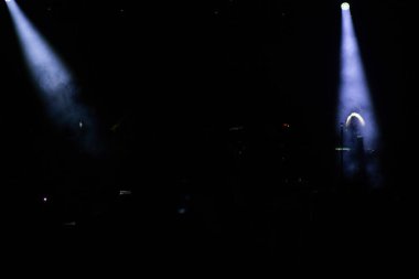 Konserdeki kalabalık ve sahne ışıklarındaki siluetler