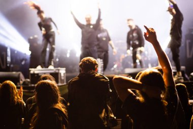 Konserdeki kalabalık ve sahne ışıklarındaki siluetler