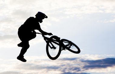 bmx bisiklet ile bir sıçrama yapan bir erkek silüeti 