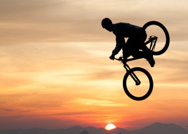 bmx bisiklet ile bir sıçrama yapan bir erkek silüeti 