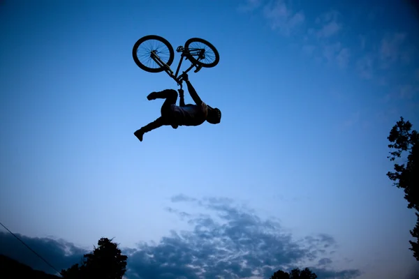 Silueta de un hombre haciendo un salto con una bicicleta bmx —  Fotos de Stock