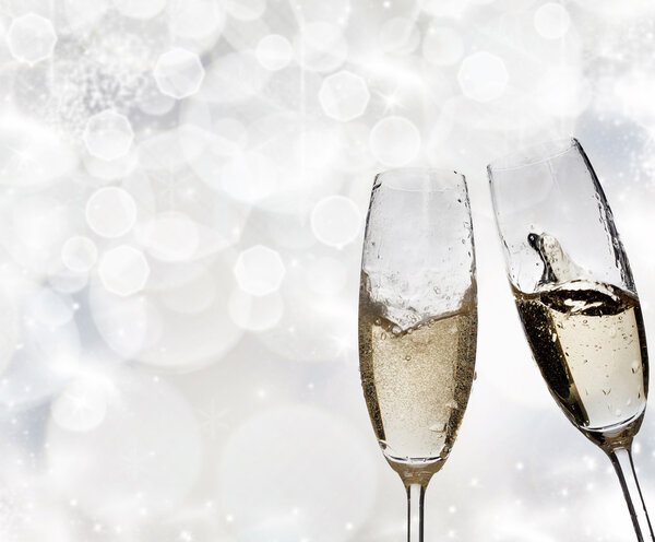 Toasting with champagne glasses on sparkling holiday background