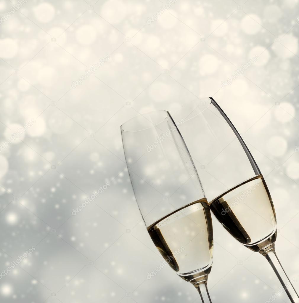 Toasting with champagne glasses on sparkling holiday background