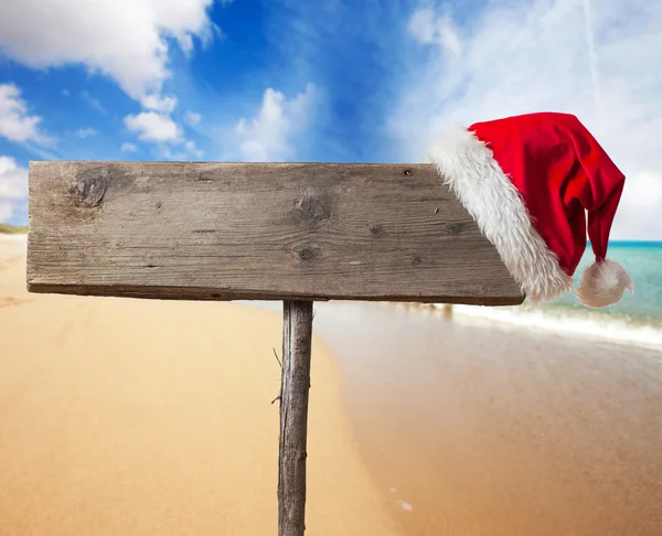 Cartello in legno con cappello di Natale sulla spiaggia tropicale — Foto Stock