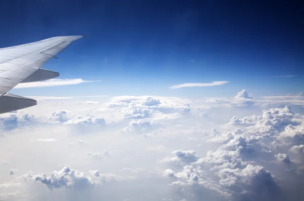 Nuvens e céu como visto através da janela de uma aeronave — Fotografia de Stock