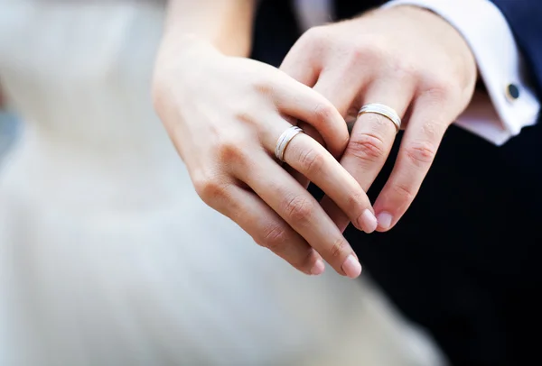 Hands and rings on wedding bouquet — Stock Photo, Image