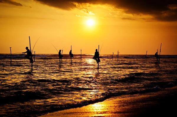 Silhuetas dos pescadores de palafitas tradicionais ao pôr do sol nea — Fotografia de Stock
