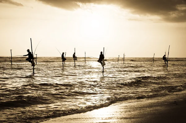 Silhouetten van de traditionele stilt vissers op de zonsondergang nea — Stockfoto