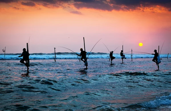 Silhuetas dos pescadores de palafitas tradicionais ao pôr do sol nea — Fotografia de Stock