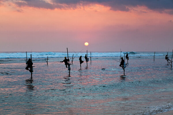 Silhouettes of the traditional stilt fishermen at the sunset nea