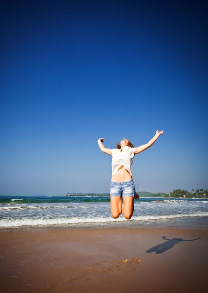 Mulher pulando no ar na praia tropical — Fotografia de Stock