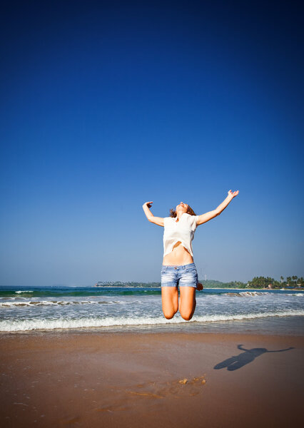 Woman Jumping In The Air On Tropical Beach